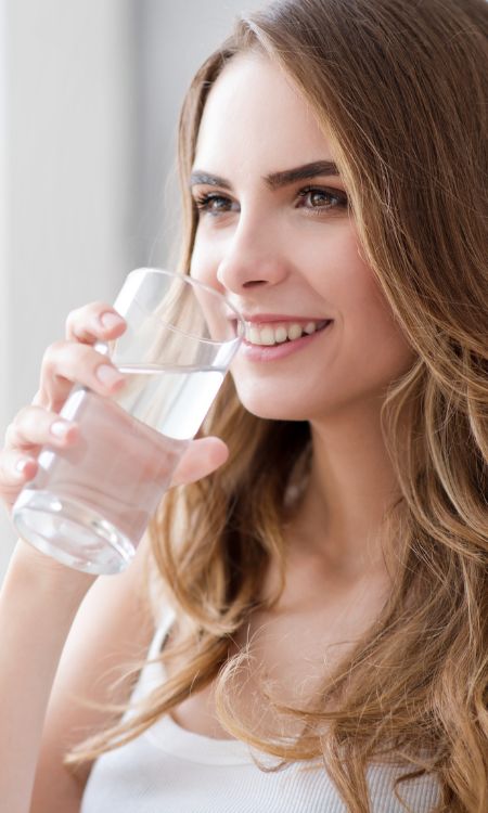 Mujer bebiendo Agua Alcalina