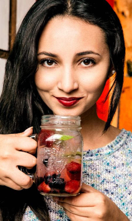 Mujer bebiendo agua frutal.